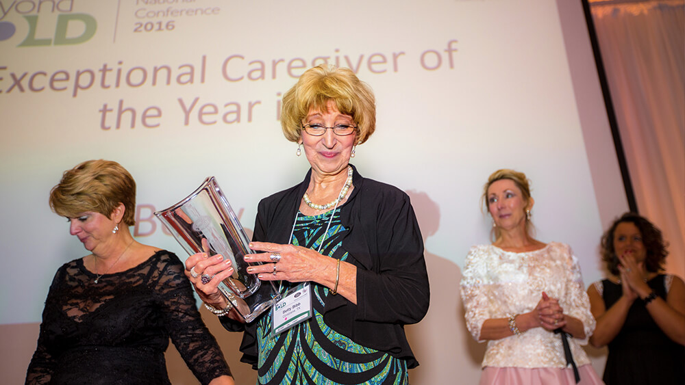 Betty holding a trophy at the Exceptional Caregiver of the Year 2016 Conference