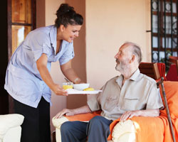 Home Helpers caregiver giving client tray of food