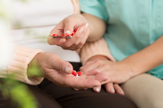 Caregiver handing medication to their client