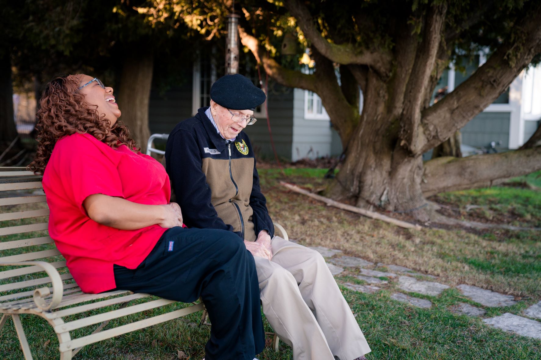 Caregiver sitting and laughing with senior