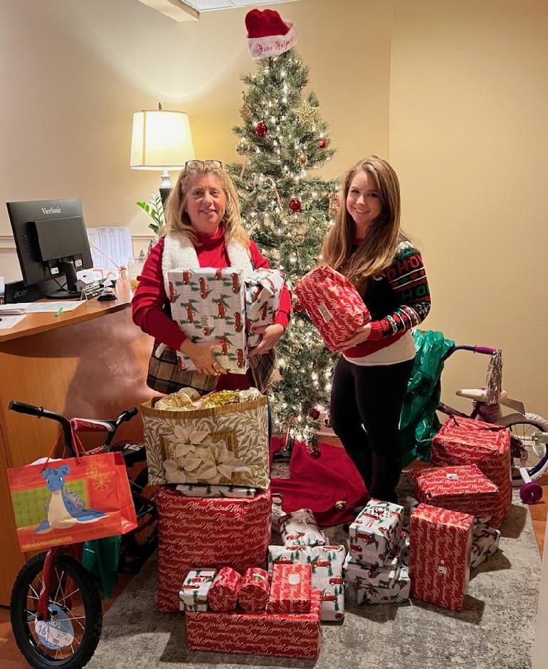 two women in front of tree with presents